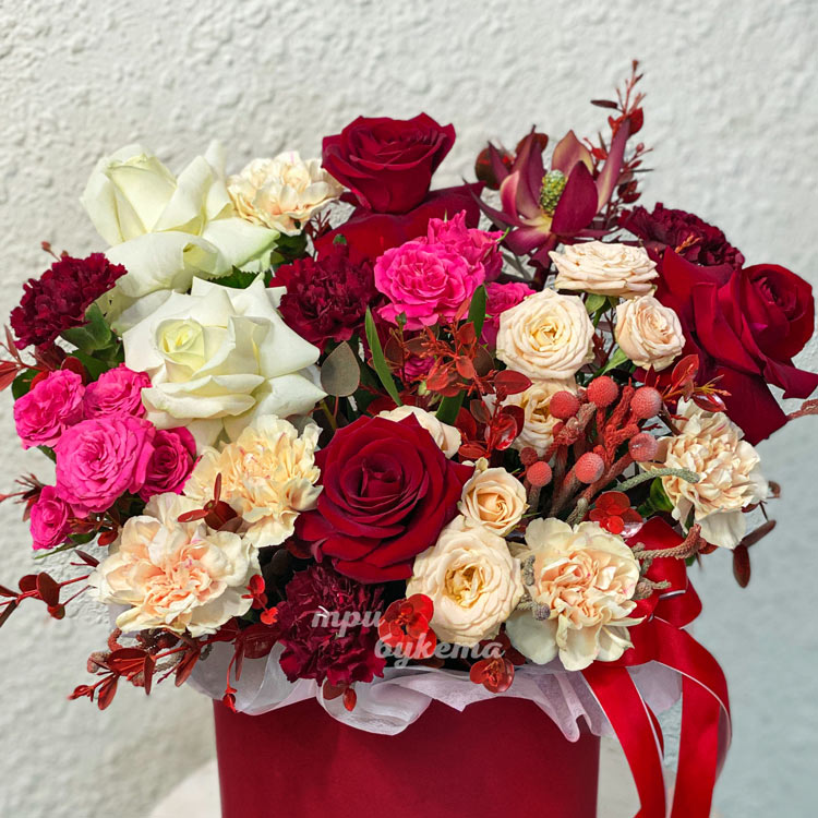 Красная коробка роз, гвоздик и зелени (крупный план)