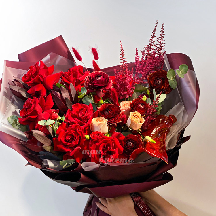 Букет красных ранункулюсов, роз и зелени (крупный план)